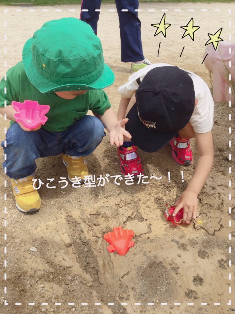 雨上がりの滑り台下の土で泥んこ遊びをしている園児たち