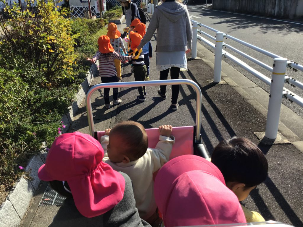 散歩リングで手をつないでお散歩する園児たちとお散歩車でお散歩する園児たち