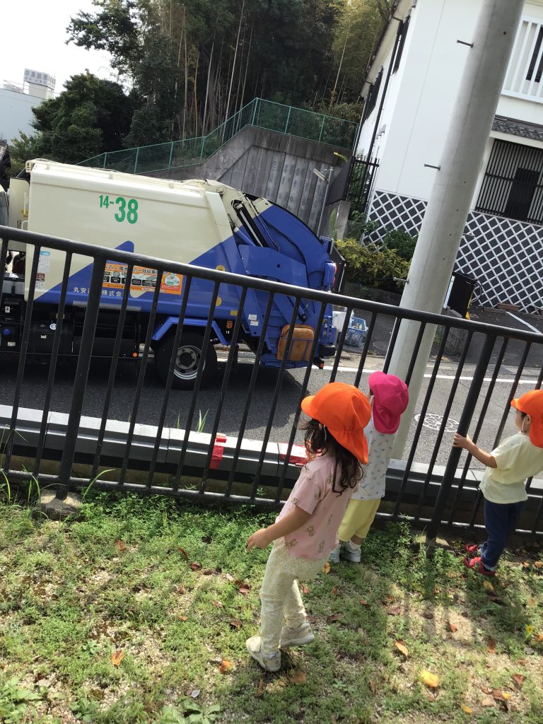 ゴミ収集車を見つめる園児たち