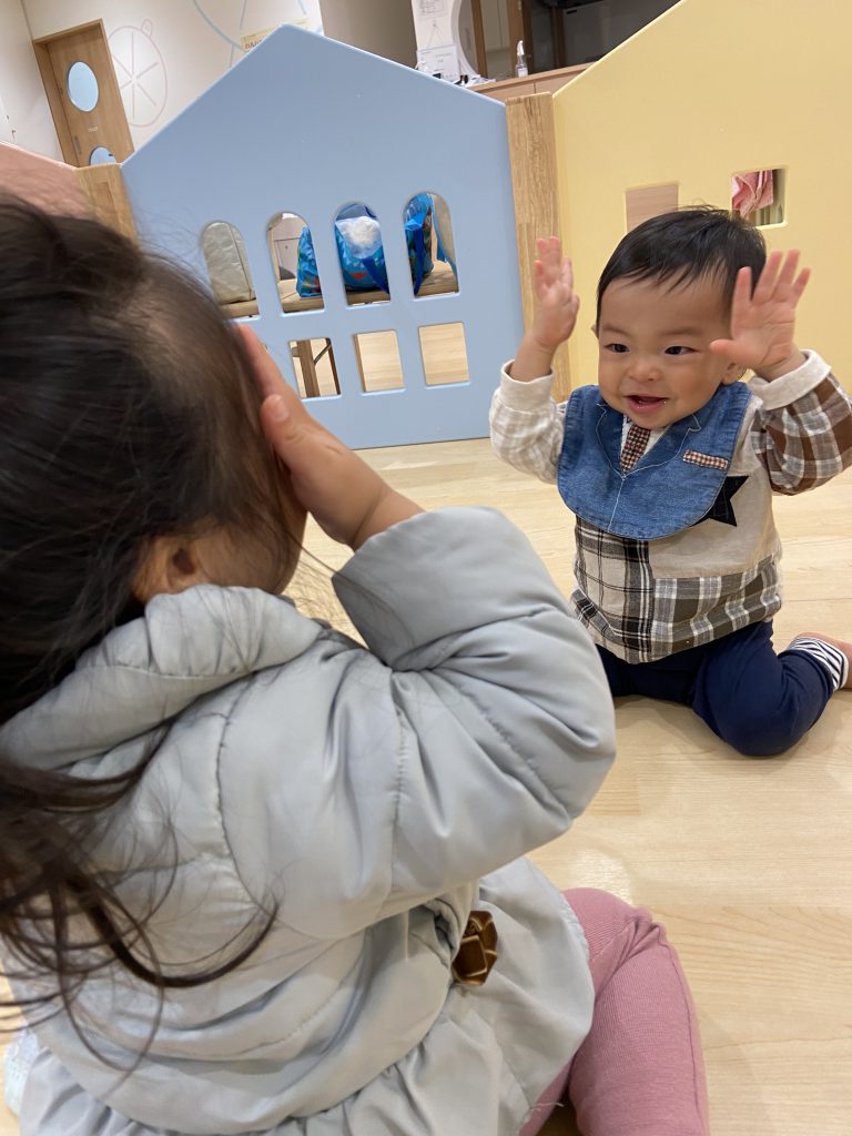 両手を挙げてまねっこする園児