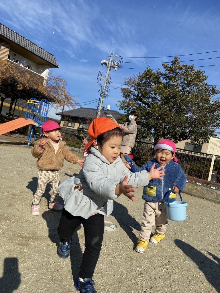 シャボン玉を追いかける園児たち