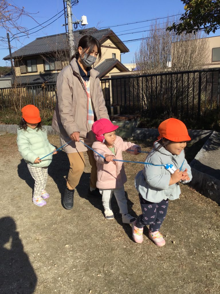 縄跳びで電車ごっこする園児たち