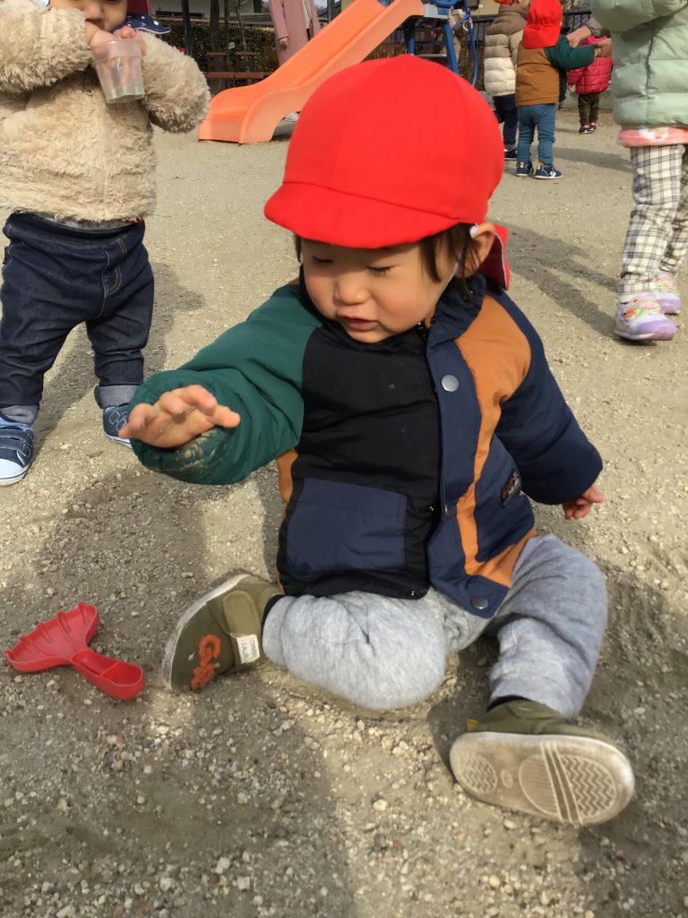 地面の土を触っている園児