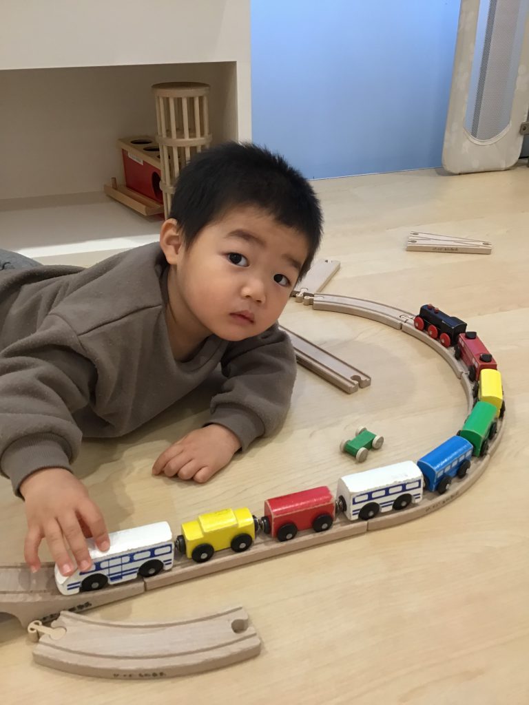 電車のおもちゃで遊ぶ園児