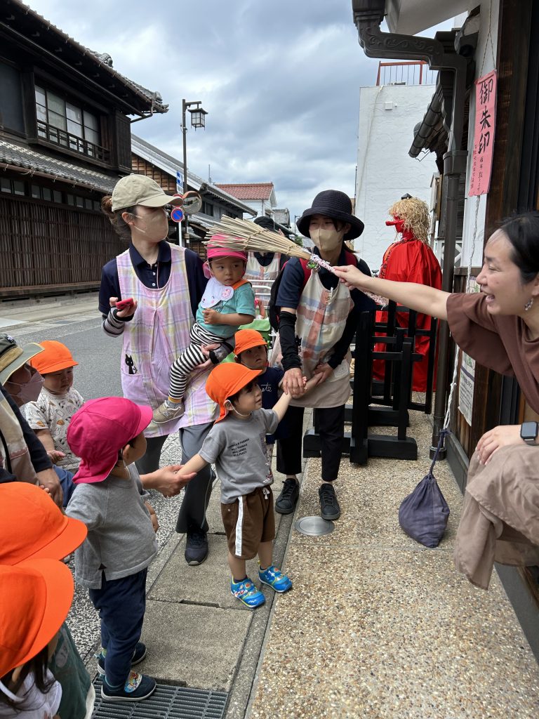 ヤツデで頭を撫でてもらう園児たち