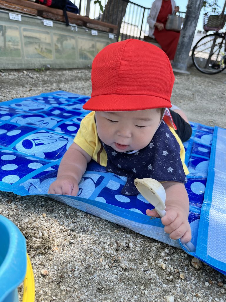 シートの上で寝転びで遊ぶ園児