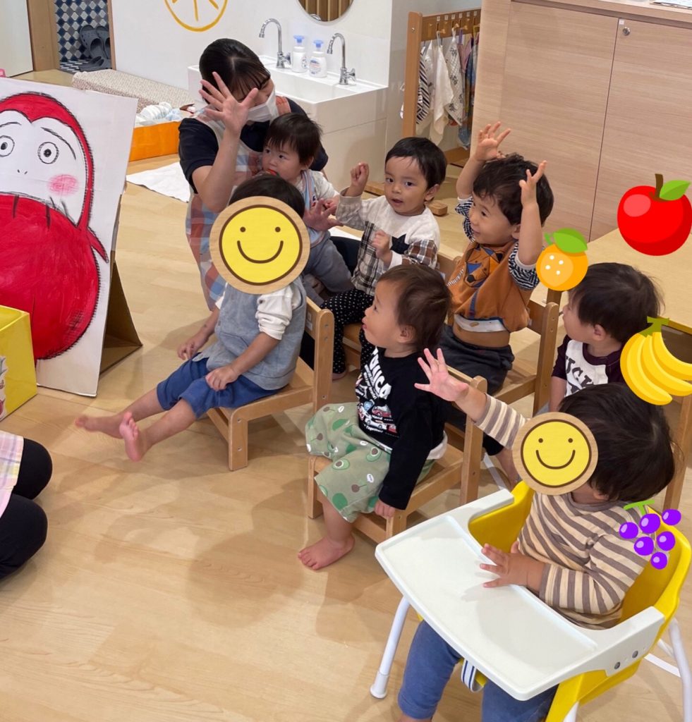 椅子に座って手を上げている園児