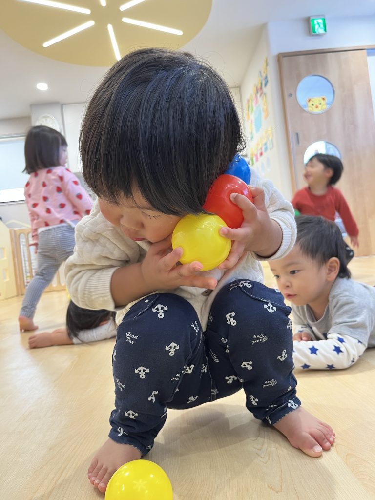 ボールをたくさん持とうと頑張る園児