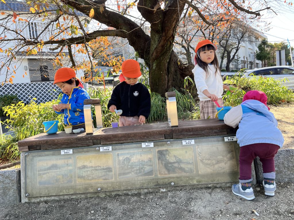 公園のベンチにものを並べる園児たち