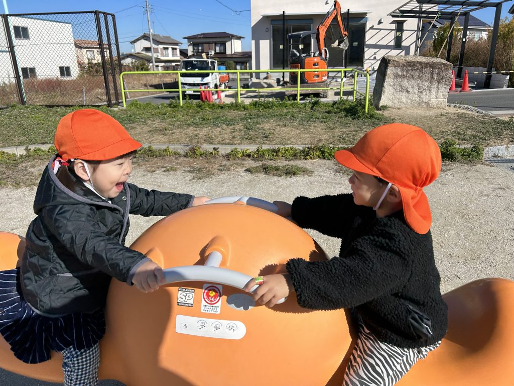 2人で遊具に乗る園児