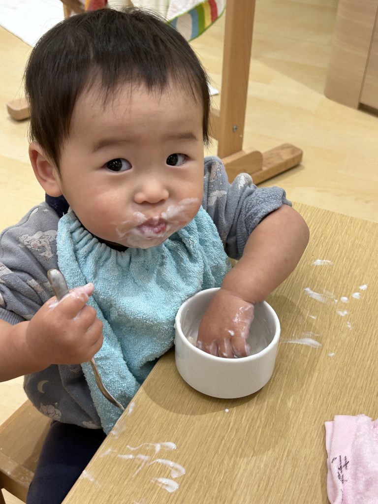 手づかみでヨーグルトを食べる園児