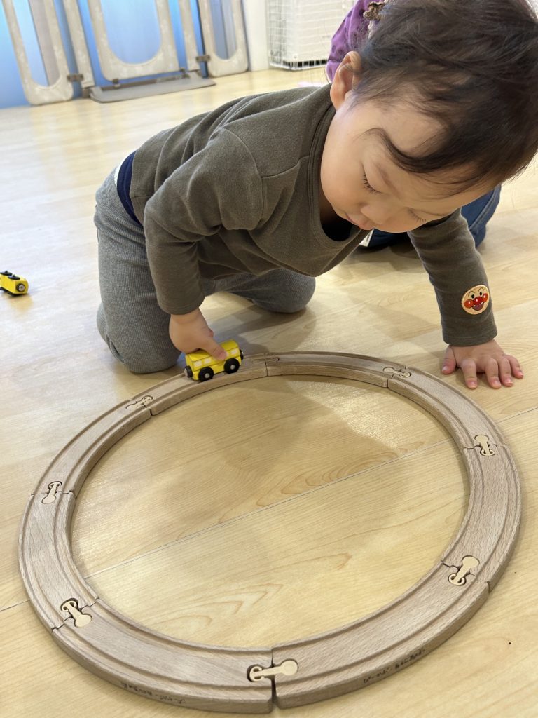 電車のおもちゃで遊ぶ園児