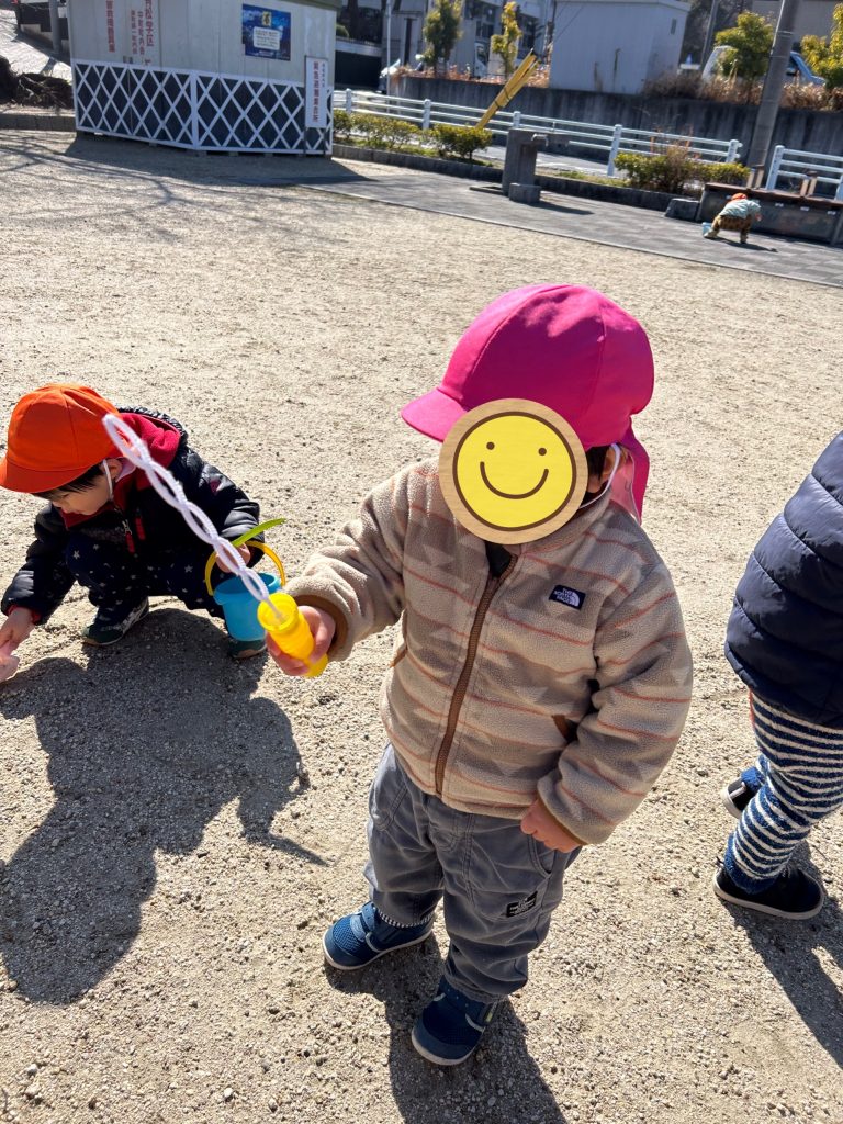 シャボン玉で遊ぶ園児