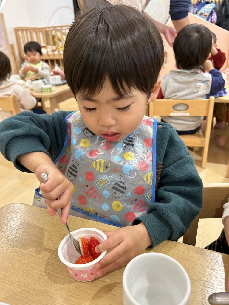 デザートのイチゴを食べる園児