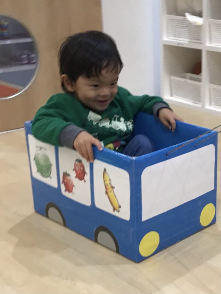 段ボールで作った車に乗って引っ張ってもらう園児