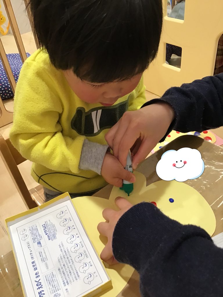 蝶々型の画用紙に絵をかく園児