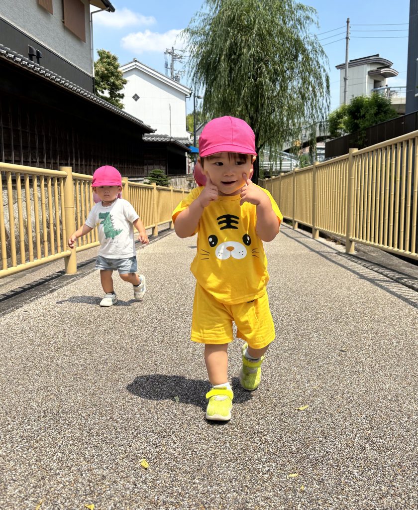 ほっぺに指を当てて笑う園児