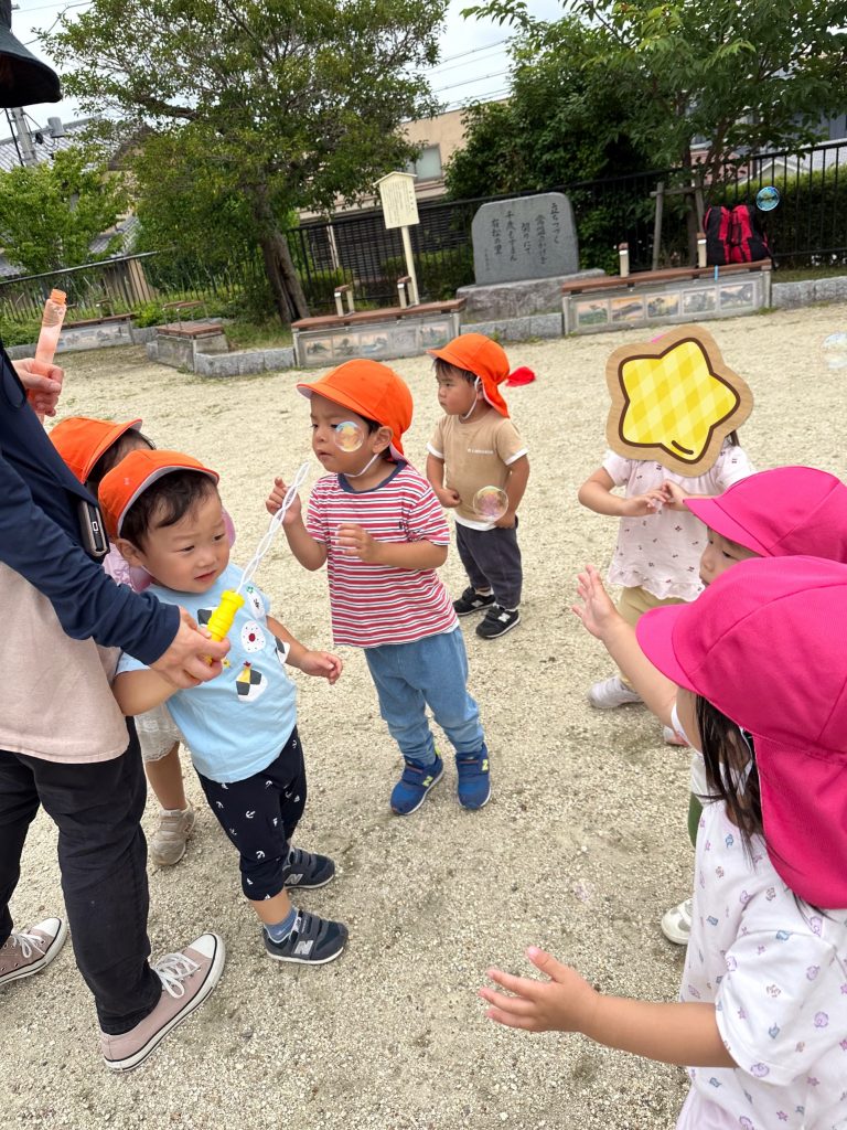 公園でシャボン玉をする園児たち