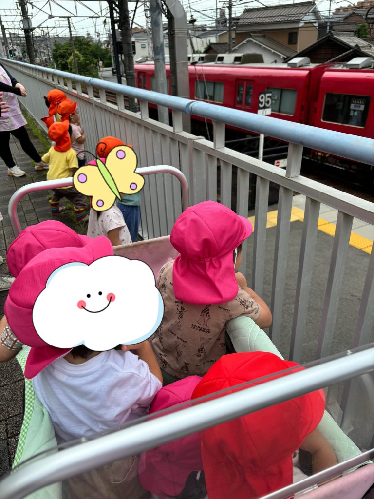 散歩中に電車を見つめる園児たち