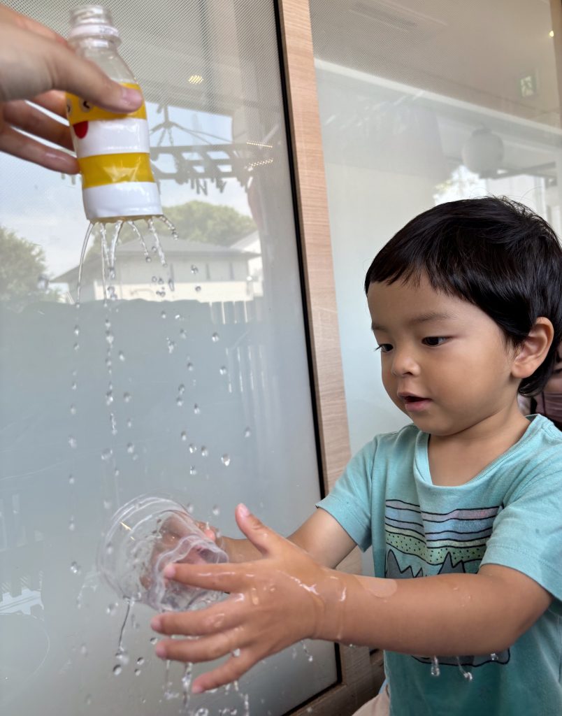 手作りのシャワーで遊ぶ園児