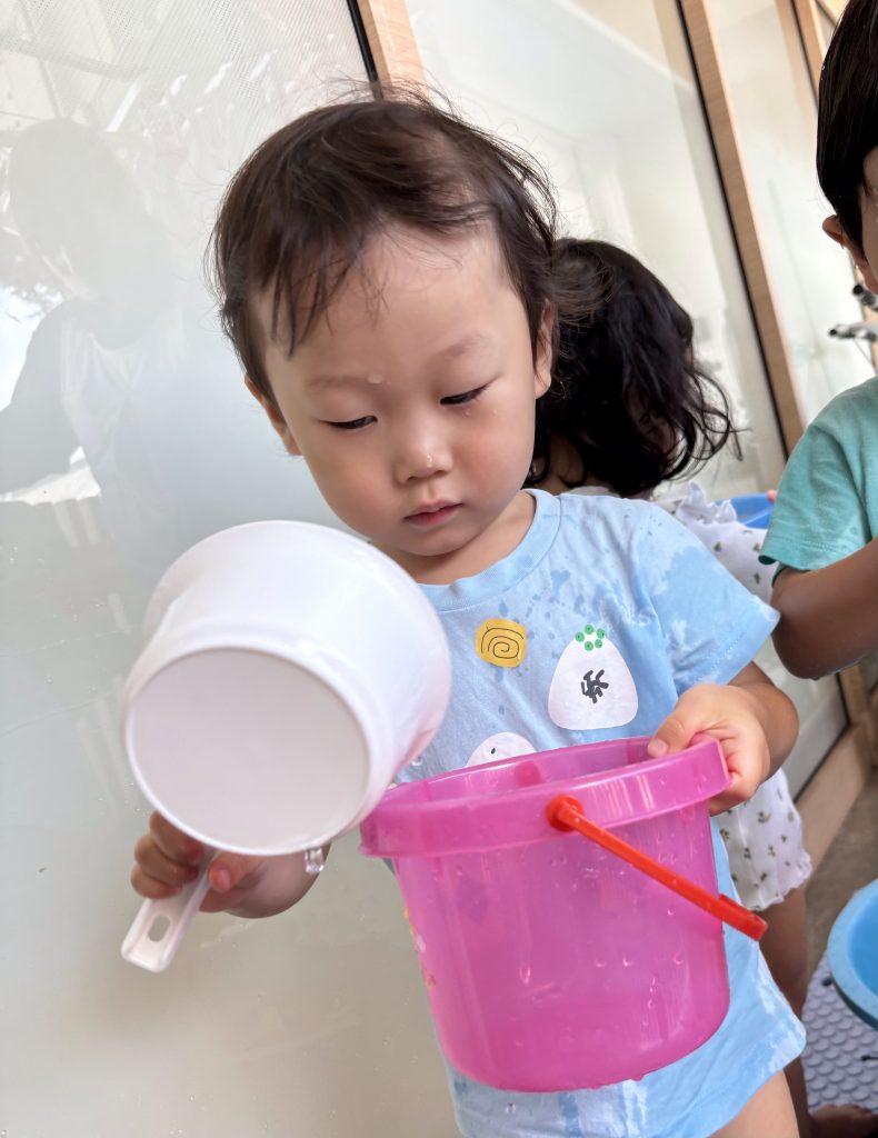 バケツに水を汲む園児